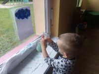 Chłopiec wykonujący deszczowa chmurkę przy pomocy spryskiwacza