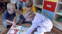 Dzieci oglądają czasopisma i książki o Kubusiu Puchatku - poznają jego przygody
